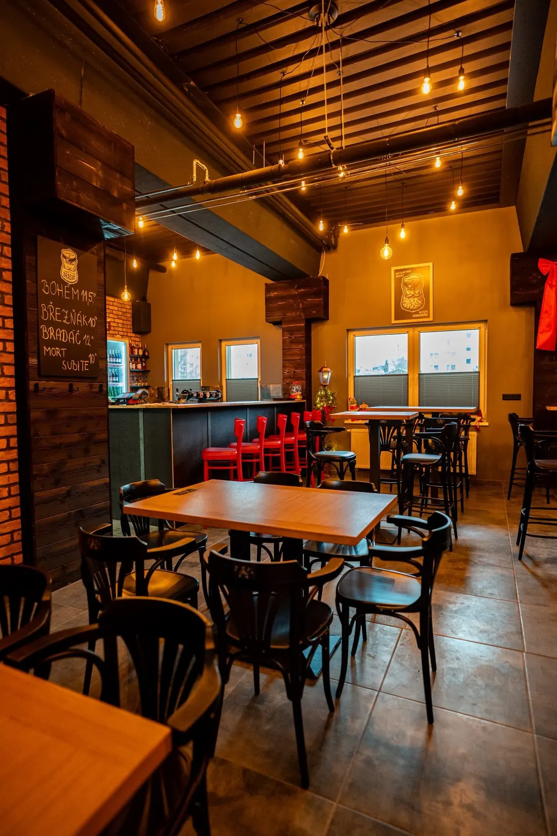 Bar s červenými stoličkami a chladničkou nápojov